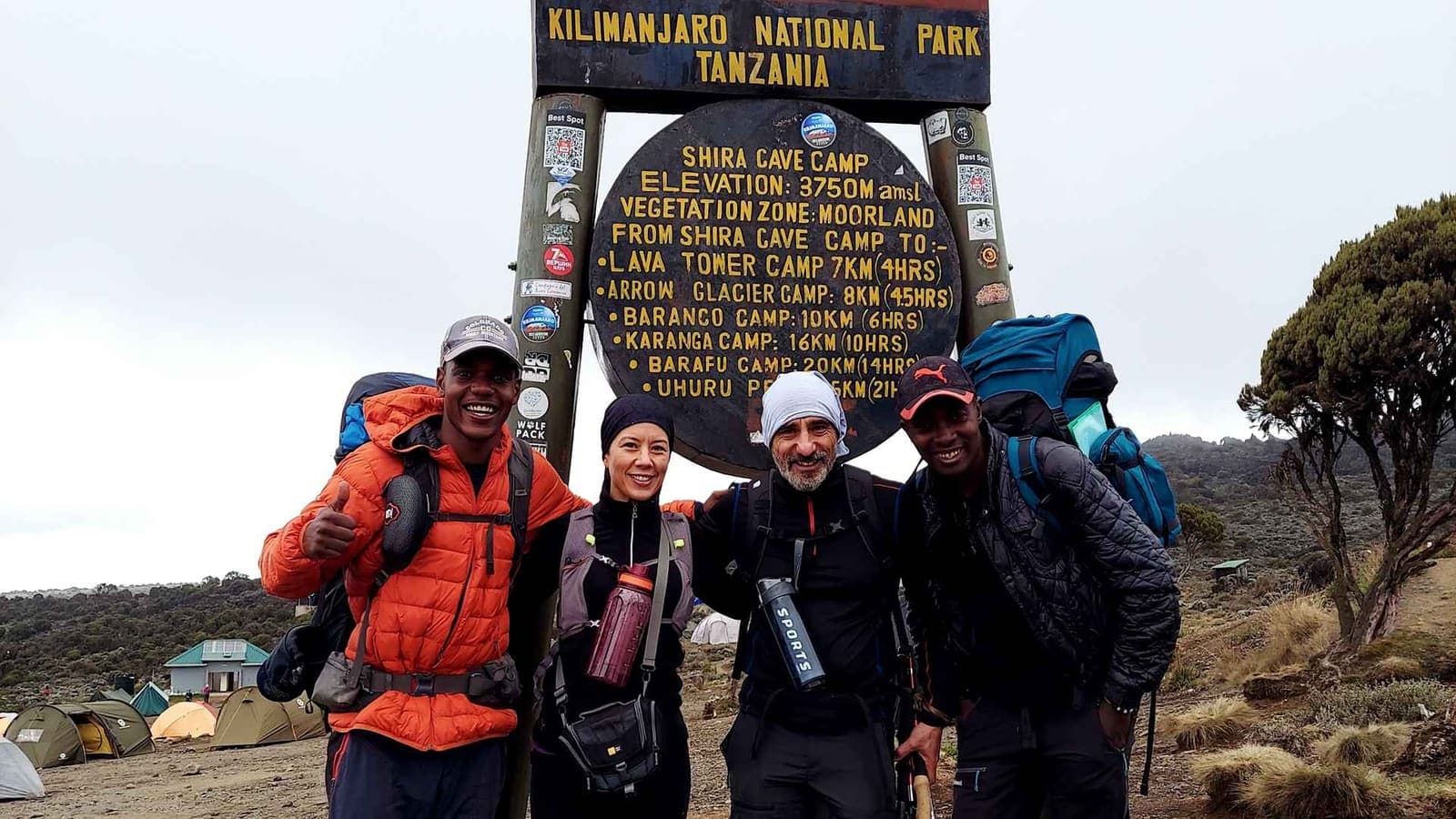 Trekkers at the Shira Cave Camp sign in Kilimanjaro National Park