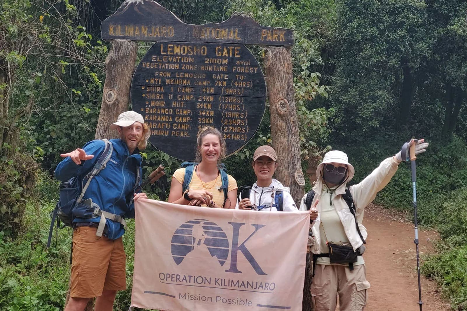 Climbers with an Operation Kilimanjaro banner at Lemosho Gate